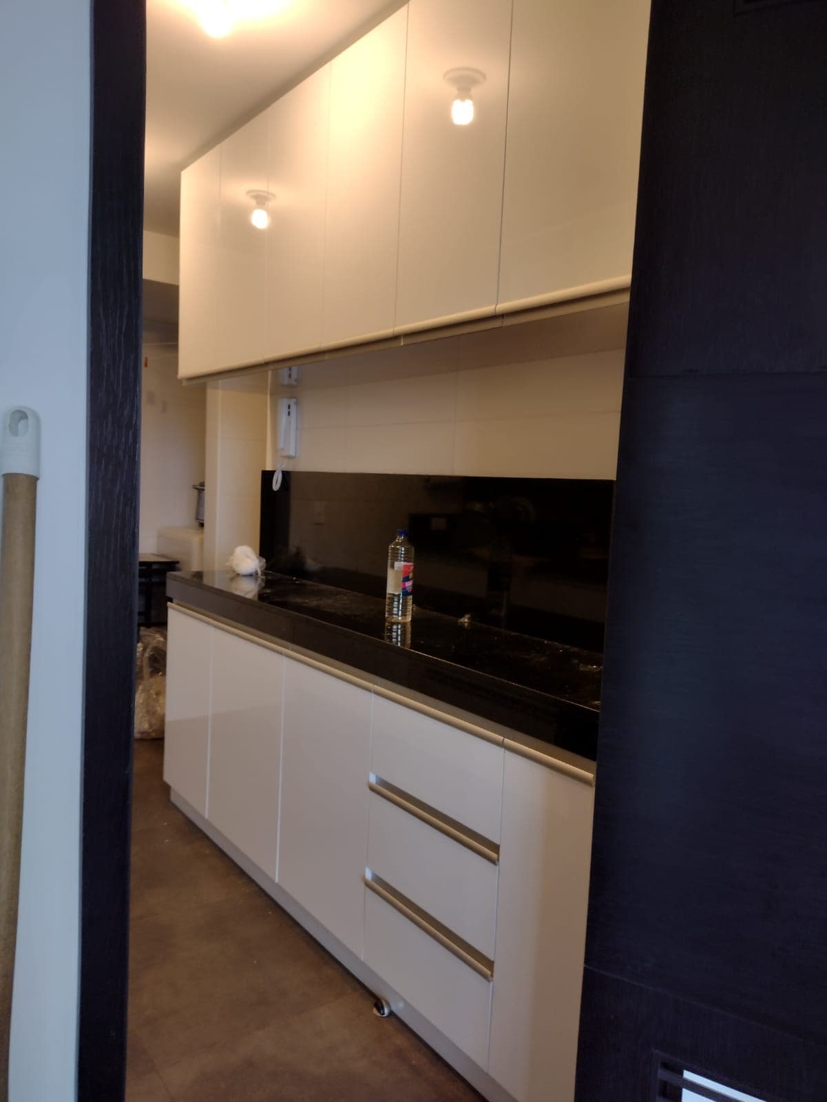 Cocina lineal blanca con mesón negro
